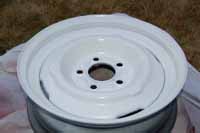 Photos shows the fully restored trailer wheel after we sanded and primed it and spray painted it using aerosol spray paint cans